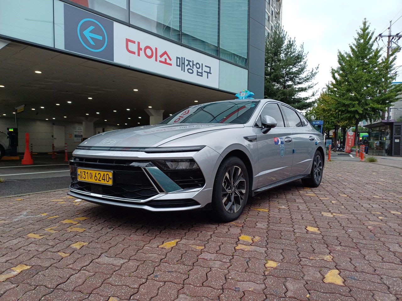A silver Hyundai Sonata taxi displaying Seoul taxi signs and registration