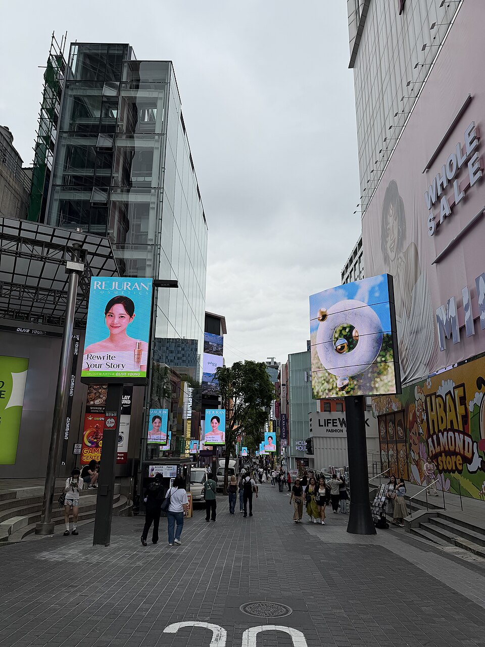 Pedestrians on Myeongdong shopping street between storefronts and large signs
